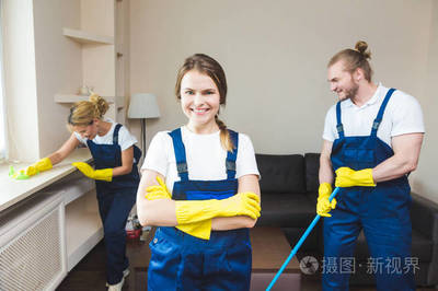 在工作過(guò)程中使用專業(yè)設(shè)備的清潔服務(wù)。專業(yè)的小廚房清潔, 沙發(fā)干洗, 窗戶和地板清洗。穿制服、工作服和橡膠手套的男人和女人